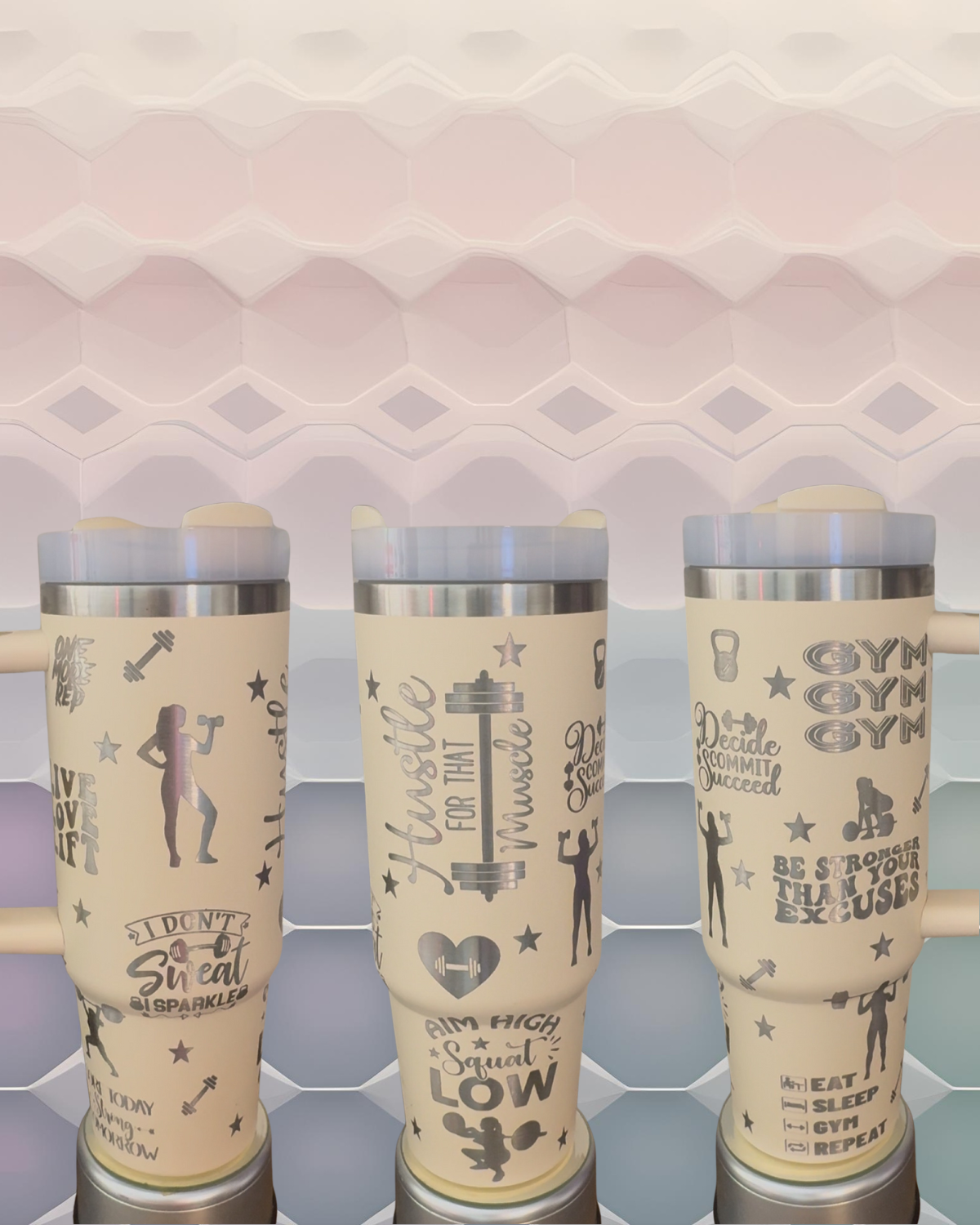 Three beige tumblers with various fitness-related text and graphics printed on them.