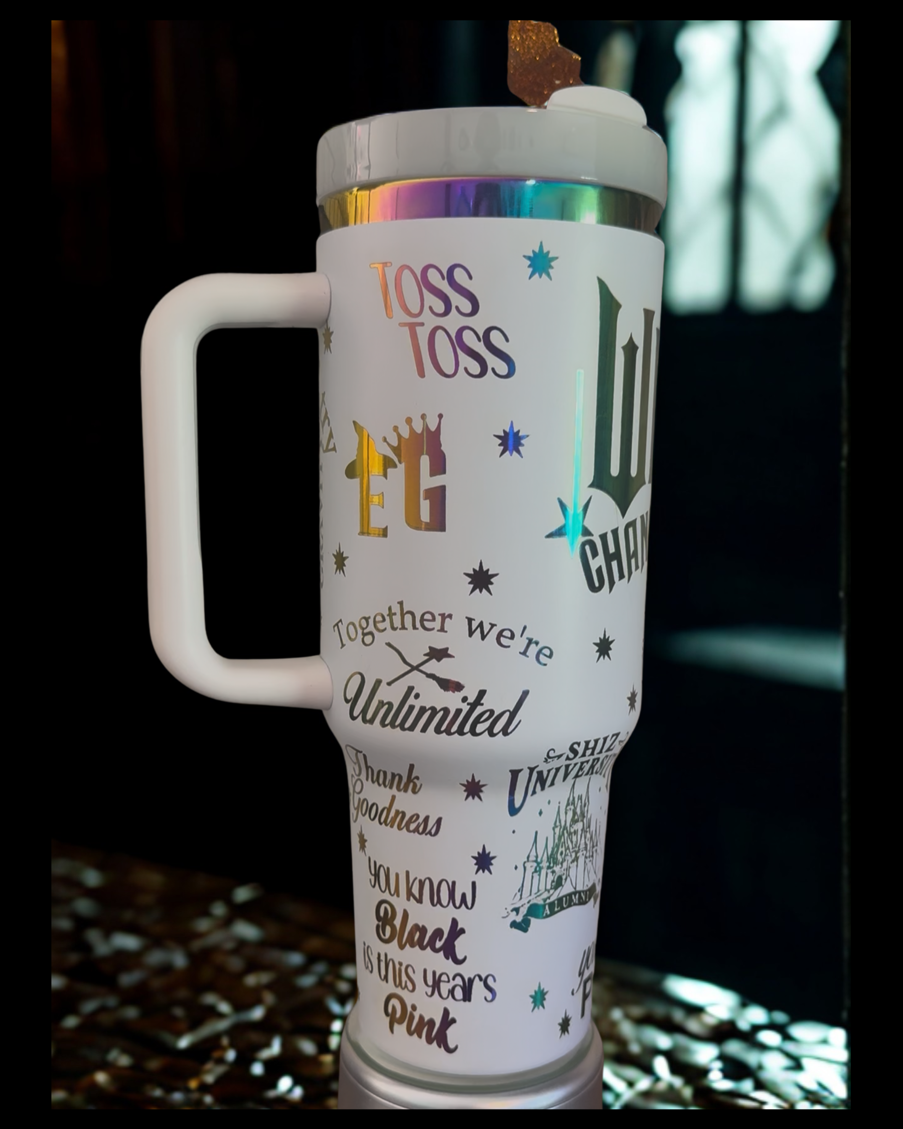 A white travel mug with various colorful and text-based designs printed on it.