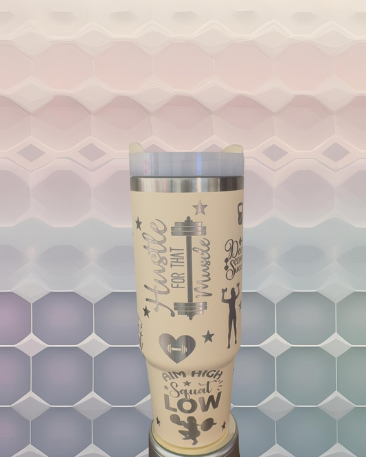 A beige insulated tumbler with various fitness-related text and graphics printed on it, including the words "Hustle for that Muscle" and "I'm High Squat Low".