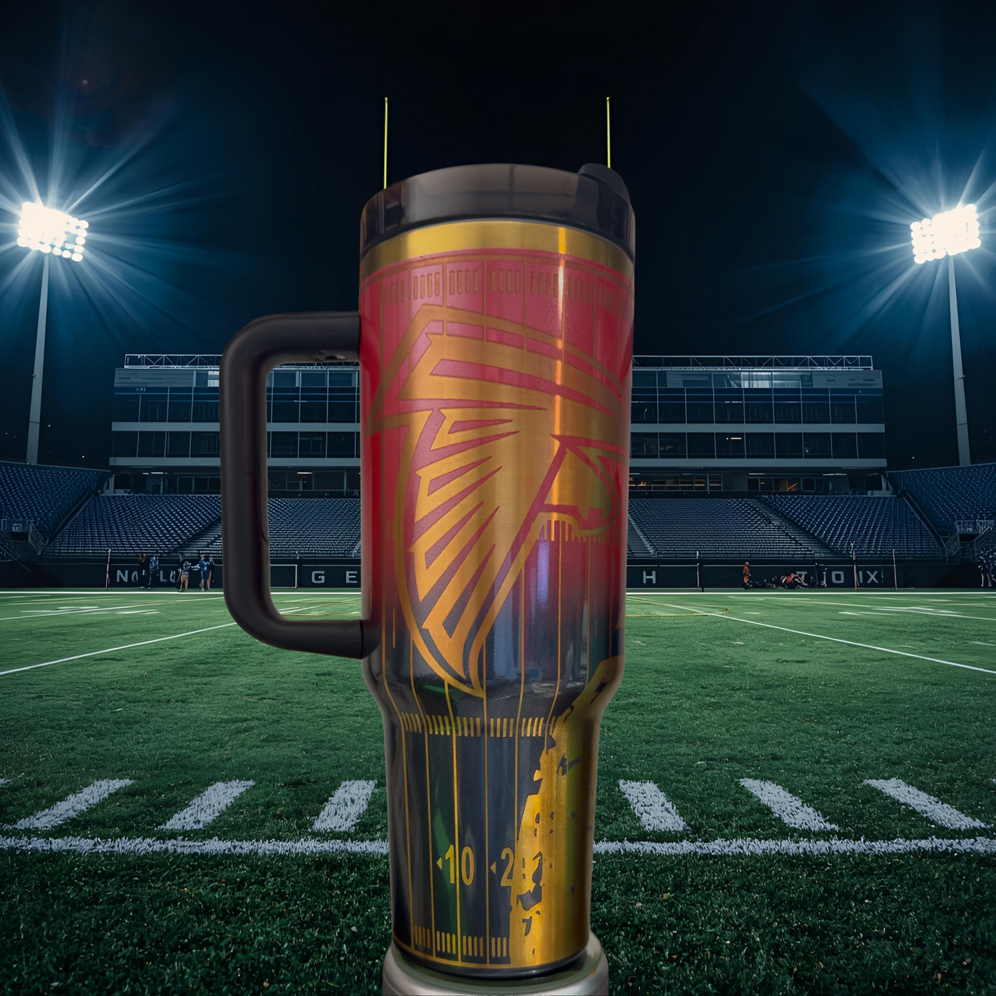 A large, colorful thermos with a football field in the background, illuminated by bright stadium lights.